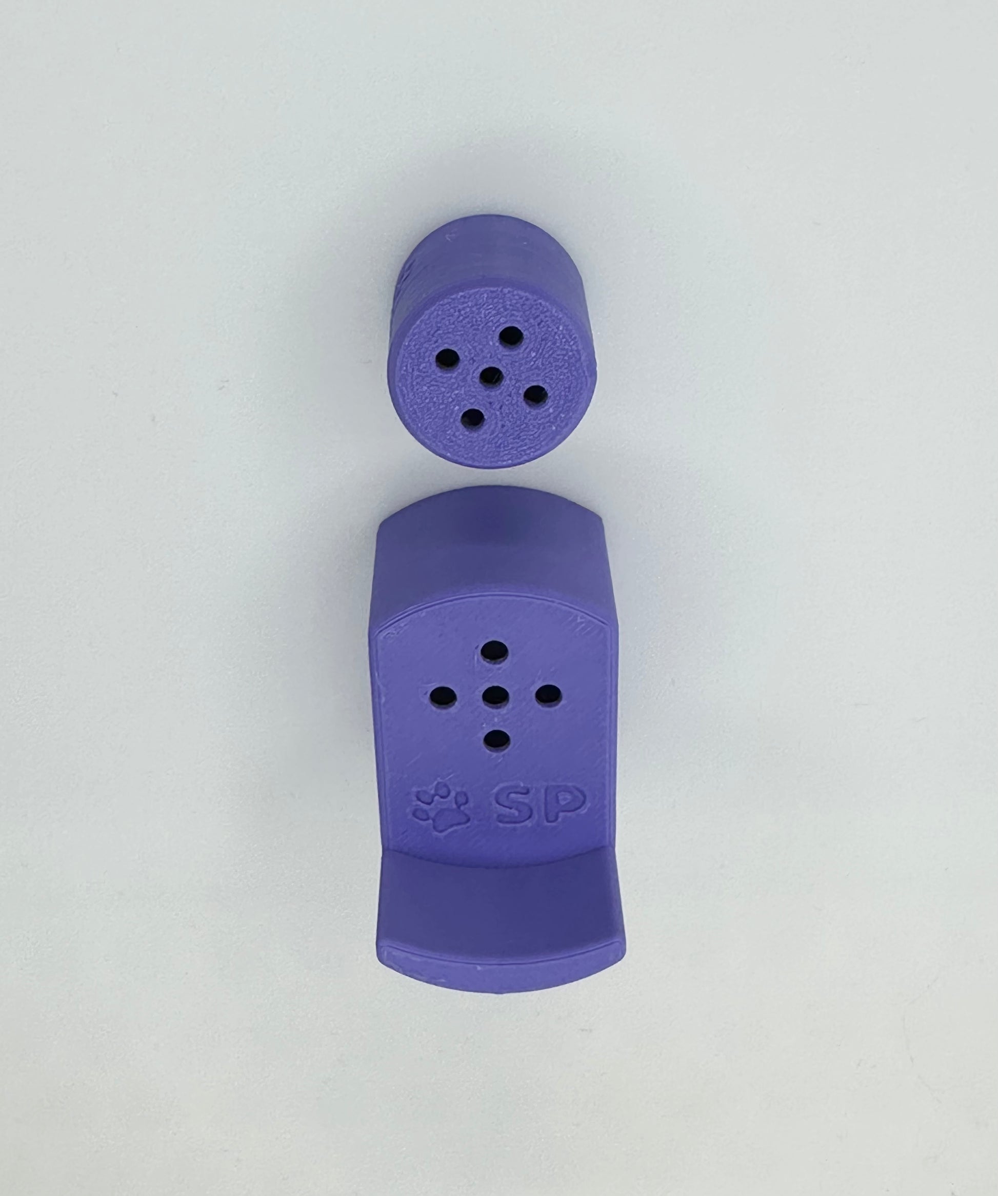 A single set of a 3D-printed Sniffy Prints pairing extension and Tiny Hide for K9 nosework in Purple. The extension in the image is magnetic and designed to go over Sniffy Prints Tiny Hide. The extension features a curved base to hold a treat, multiple small holes for odor to pass through, and an embossed 'SP' logo with a paw print.