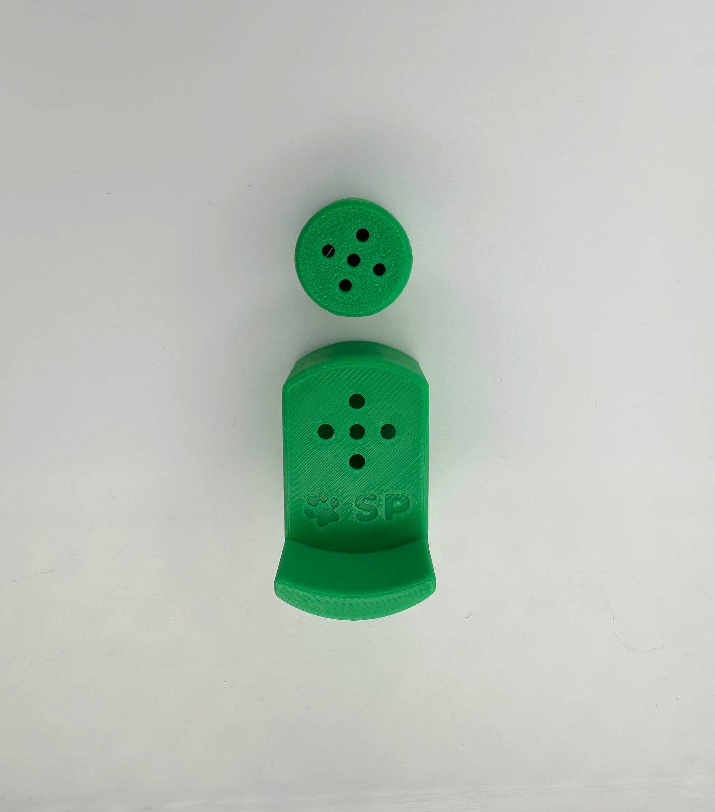 A single set of a 3D-printed Sniffy Prints pairing extension and Tiny Hide for K9 nosework in Green. The extension in the image is magnetic and designed to go over Sniffy Prints Tiny Hide. The extension features a curved base to hold a treat, multiple small holes for odor to pass through, and an embossed 'SP' logo with a paw print.