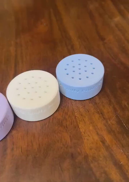 A video showing multiple Sniffy Prints odor pods for nosework arranged in a row, highlighting their design and colors